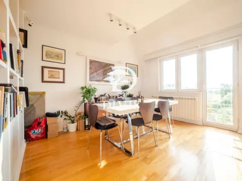Living room with a dining table and bookshelves. - image 11
