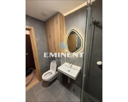 Modern bathroom with a walk-in shower, washbasin, toilet, and wooden cabinetry. - image 4