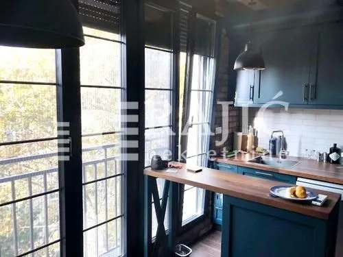 Modern kitchen with a bar counter and a dining table by the window.