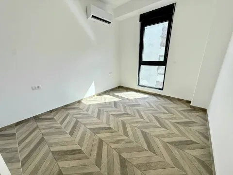 Empty room with light walls, wooden flooring, and an air conditioner. - image 5