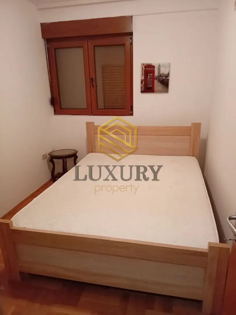 Furnished bedroom with a double bed and a window.