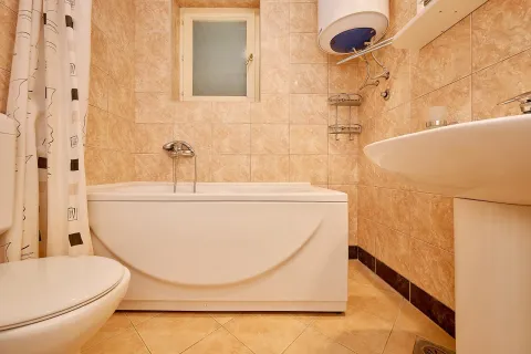 Manje kupatilo obloženo keramičkim pločicama sa kadom, umivaonikom i wc šoljom. - image 15