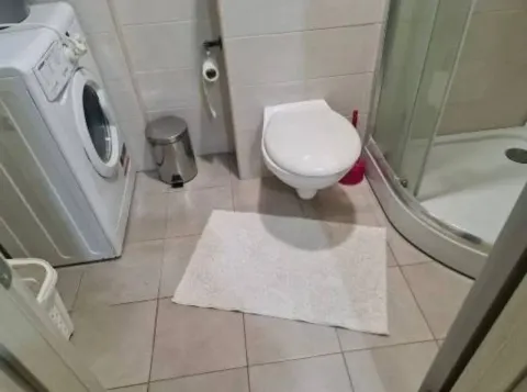 Kupatilo opremljeno tuš kabinom, WC šoljom i veš mašinom. - image 5