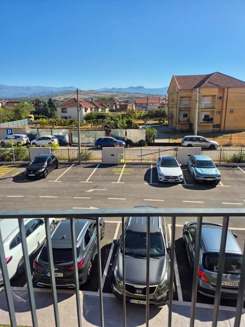 Pogled sa terase na parking i okolne zgrade.