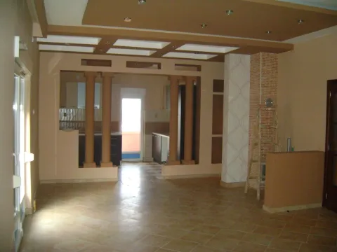 A spacious empty room featuring decorative columns and a suspended ceiling. - image 3