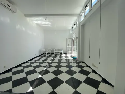 Svijetla prazna prostorija sa crno-bijelim podnim pločicama. - image 2