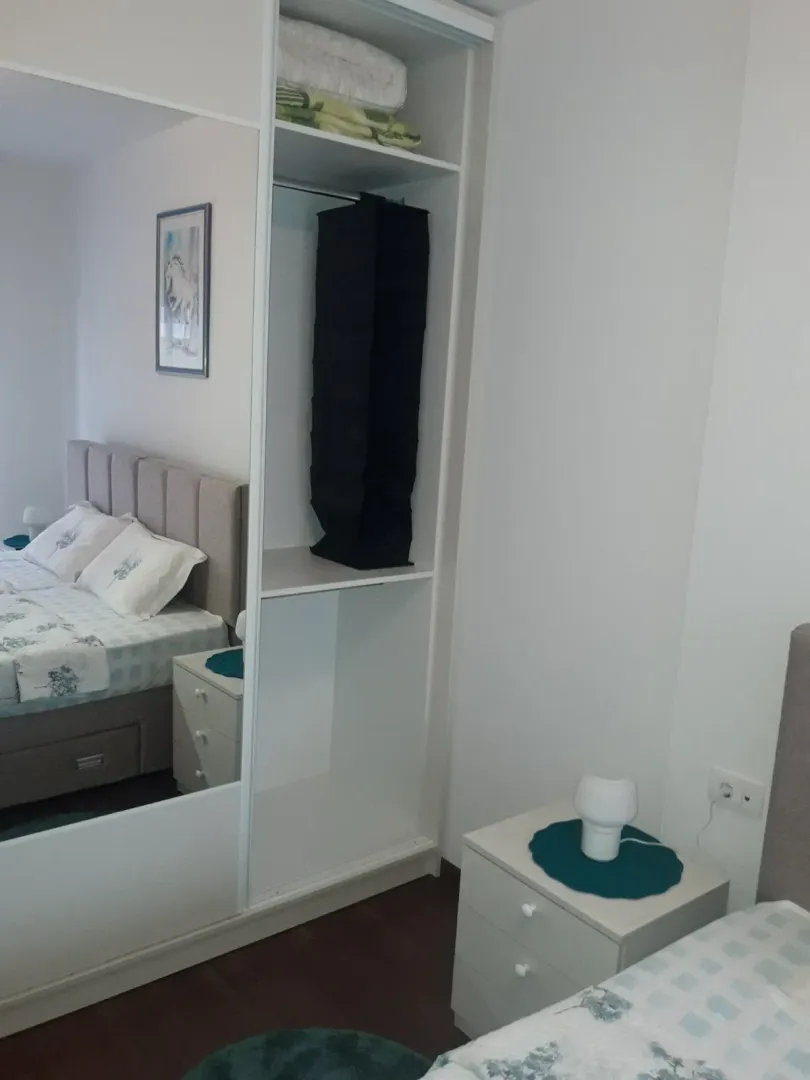 Bright bedroom featuring a built-in wardrobe with a mirror.