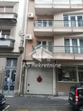 View of the building facade and entrance with a garage door. - image 21