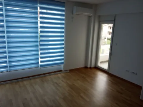 Prazna soba sa drvenim podom, velikim prozorom i klima uređajem. - image 3