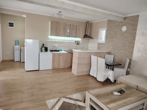 Living room with kitchen and dining area in bright tones. - image 4