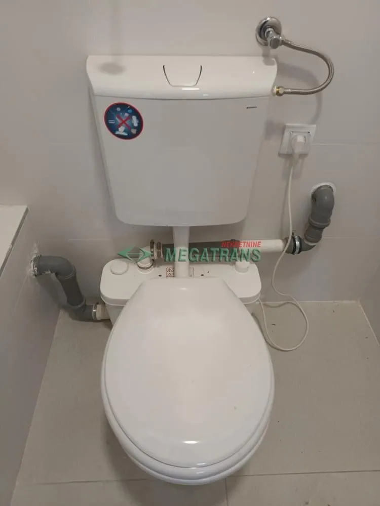View of a white toilet bowl with a cistern in the bathroom.