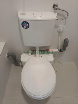 View of a white toilet bowl with a cistern in the bathroom. - image 4