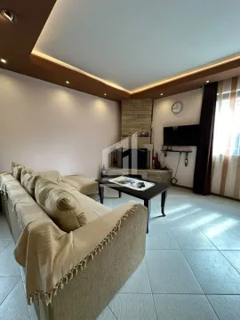 Dnevna soba sa garniturom, stočićem i kaminom u uglu. - image 3