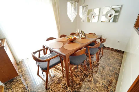 Dining room with a wooden table, chairs, and chandeliers. - image 4