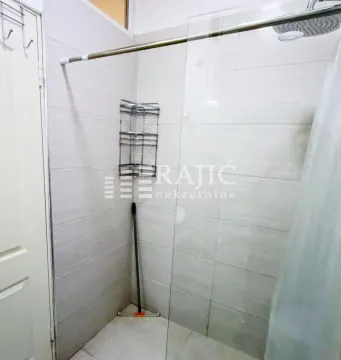 View of the shower cabin with a glass partition in a tiled bathroom. - image 7