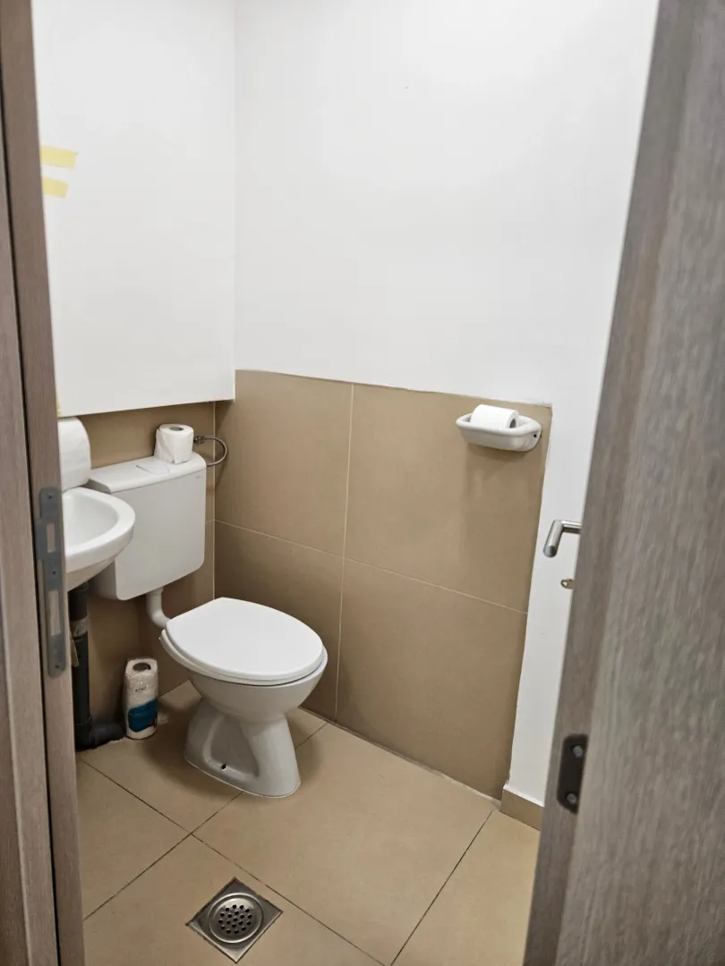Small bathroom with a toilet, sink and ceramic tiles.
