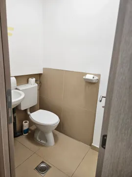 Small bathroom with a toilet, sink and ceramic tiles. - image 8
