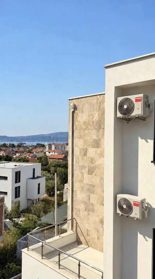 Pogled sa terase na okolne zgrade i pejzaž.
