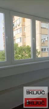 Pogled kroz velike prozore na okolne zgrade i zelenilo. - image 10
