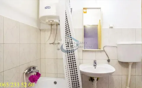 Small bathroom with a bathtub, washbasin, water heater, and mirror. - image 4
