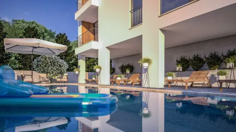Vanjski bazen ispred moderne zgrade sa ležaljkama za sunčanje. - image 4