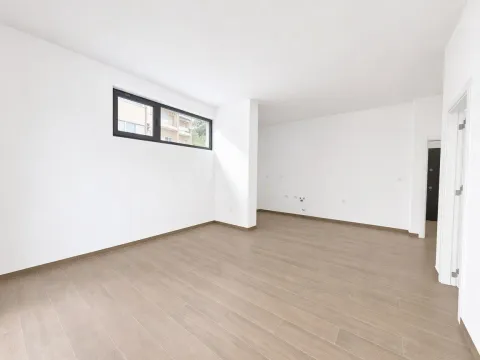 Prazna soba sa bijelim zidovima, drvenim podom i prozorom. - image 18