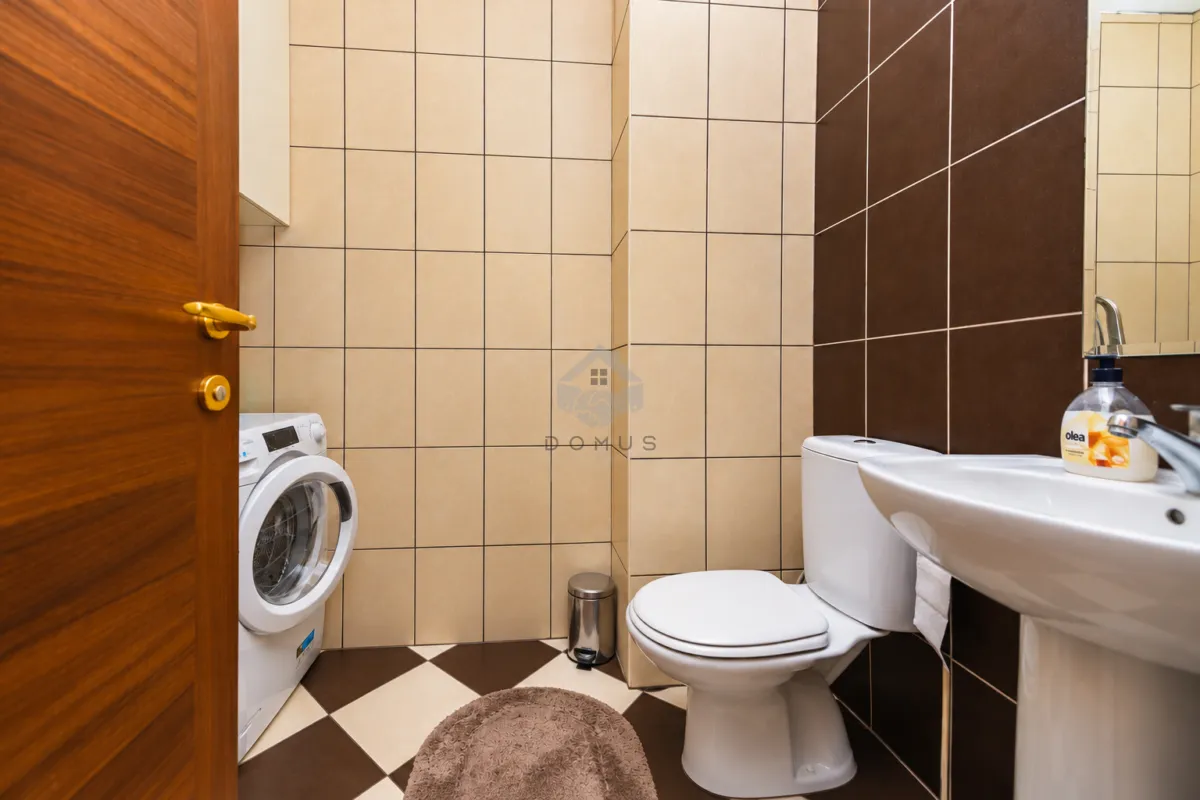Kupatilo opremljeno toaletom, umivaonikom i veš mašinom.