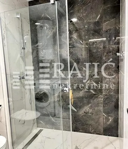 Modern bathroom with a walk-in shower and marble tiles.