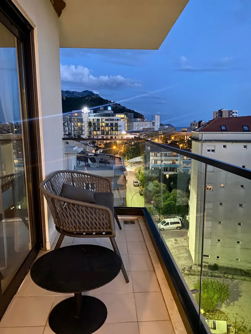Namješten balkon sa garniturom za sjedenje i pogledom na grad.