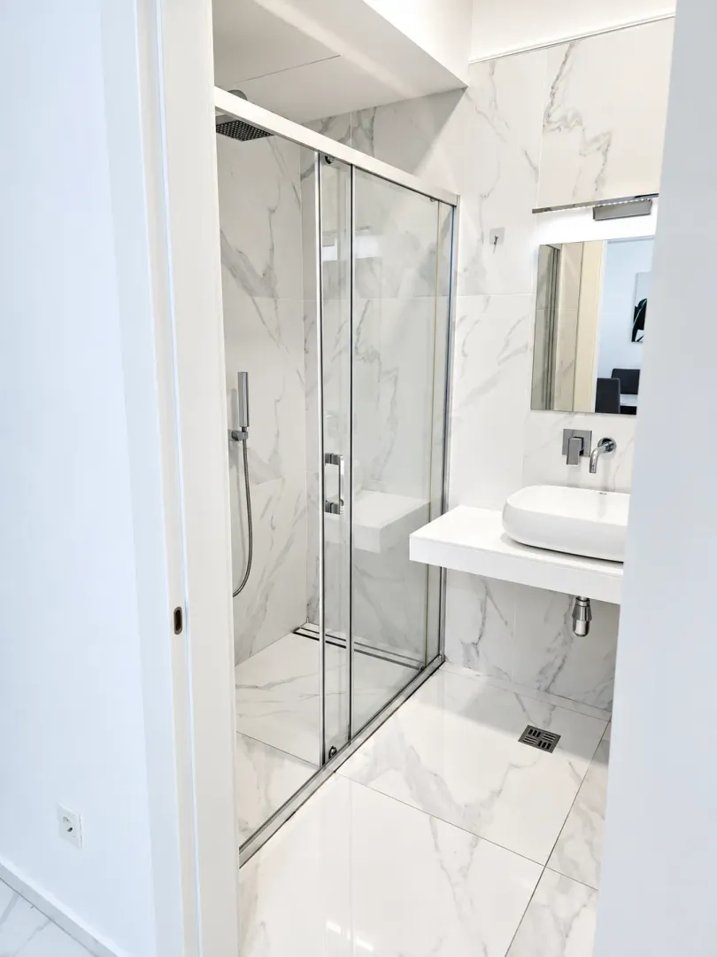 Modern bathroom with a shower cabin and a sink.