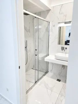 Modern bathroom with a shower cabin and a sink. - image 9