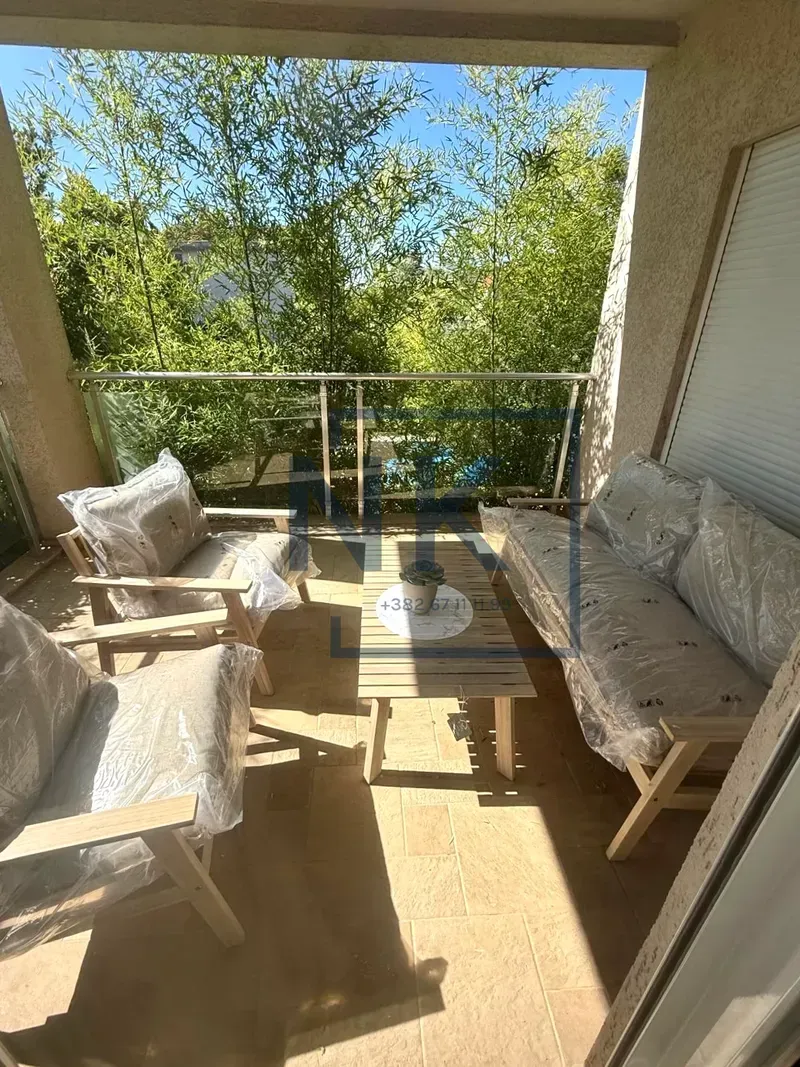 Covered terrace furnished with seating and a view of greenery.