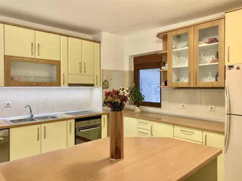 Bright kitchen with light yellow cabinets, wooden countertops, and a kitchen table. - image 6