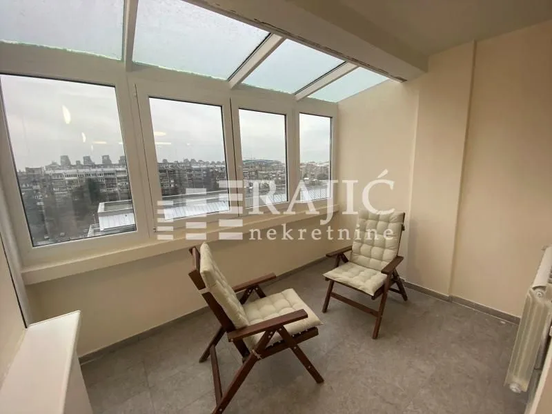 Glazed terrace with wooden chairs and roof windows.