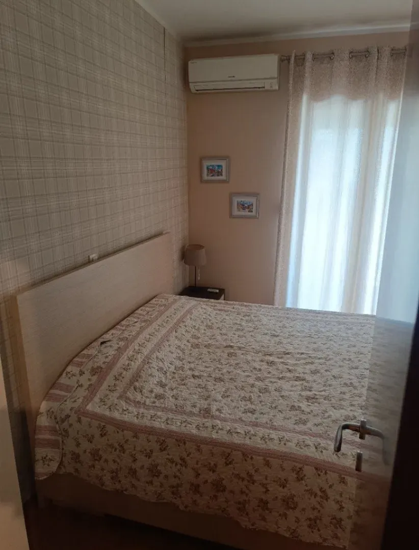 Namještena spavaća soba sa bračnim krevetom.