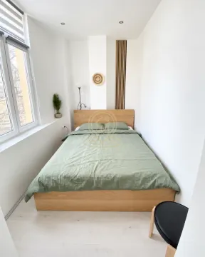 Spavaća soba sa bračnim krevetom, drvenim detaljima i prozorom. - image 6