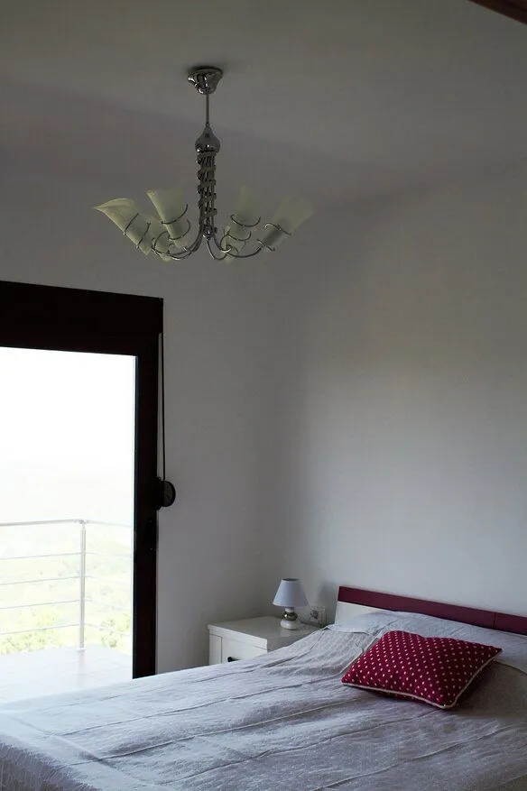 Bedroom with a double bed, bedside table, and access to the terrace.