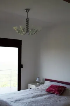 Bedroom with a double bed, bedside table, and access to the terrace. - image 8