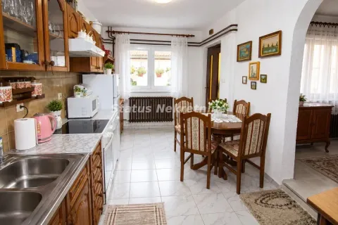 Tradicionalna kuhinja sa drvenim elementima i trpezarijskim stolom. - image 6