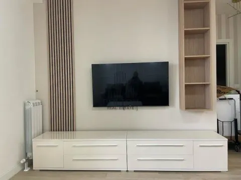 Dnevna soba sa TV-om, niskom komodom i zidnim panelom. - image 10