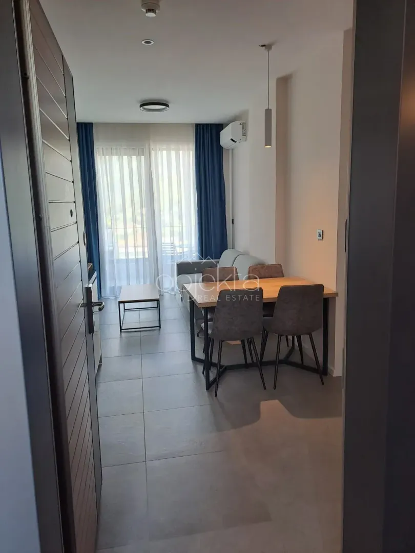 View from the hallway into the living room with a dining area and access to the terrace.