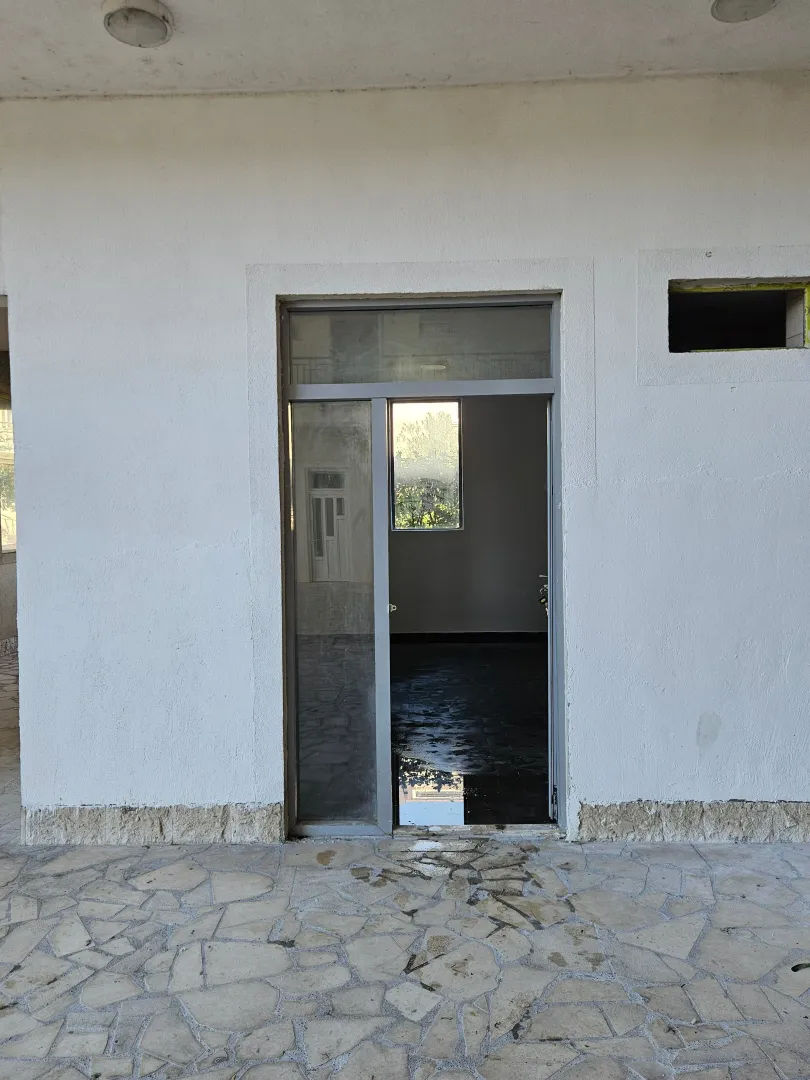Entrance door and exterior part of the building with tiled floor.