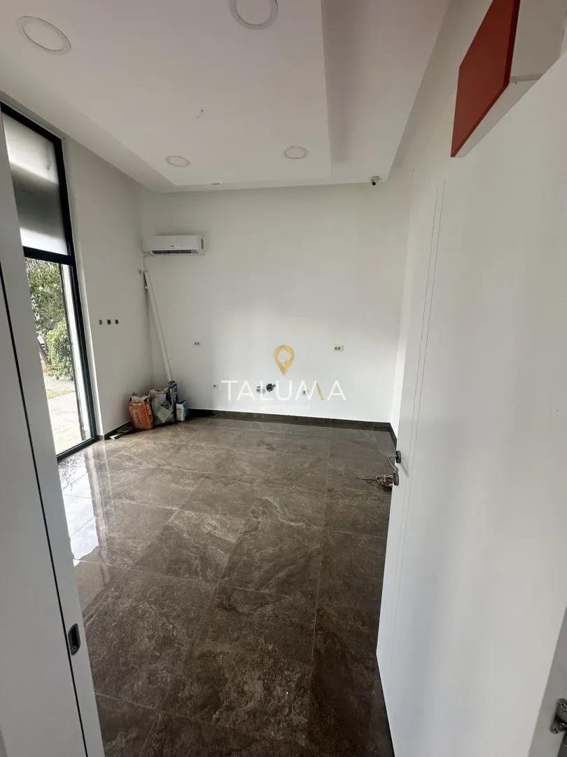 An empty room with ceramic floor tiles and an air conditioning unit on the wall.