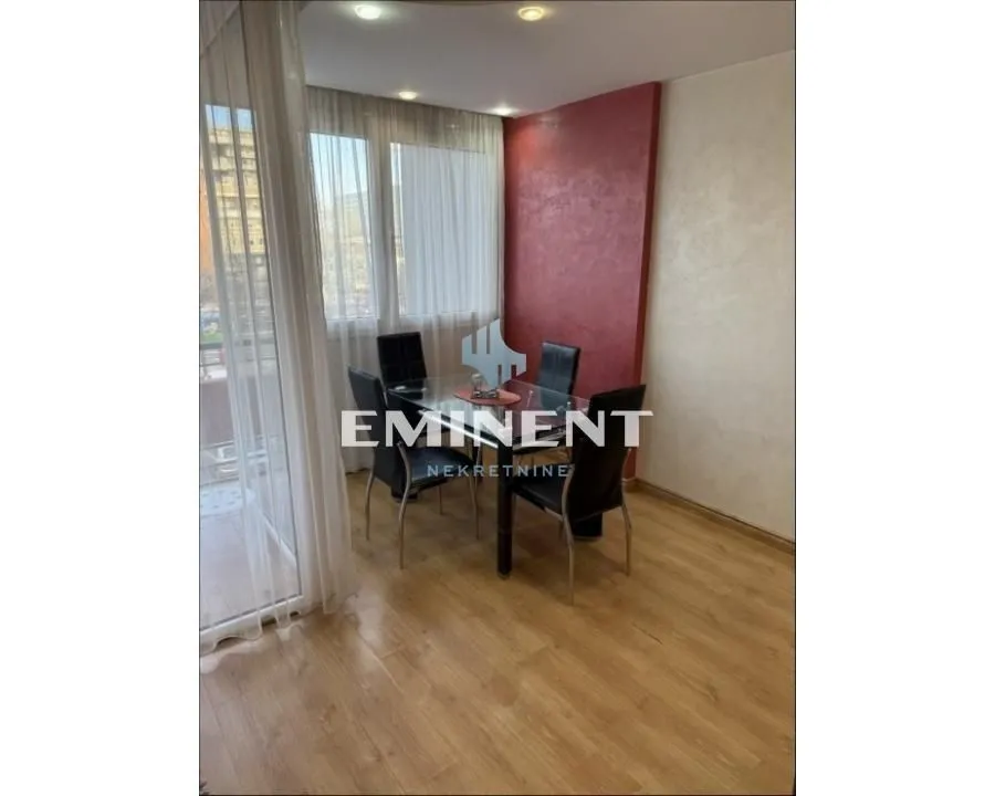 Dining area with a table and chairs next to the balcony door.