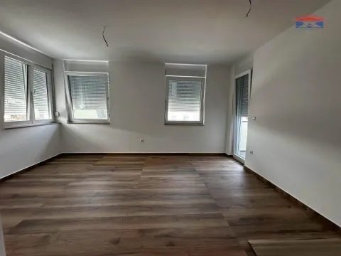 Prazna prostorija sa laminatnim podom i belim zidovima. - image 3