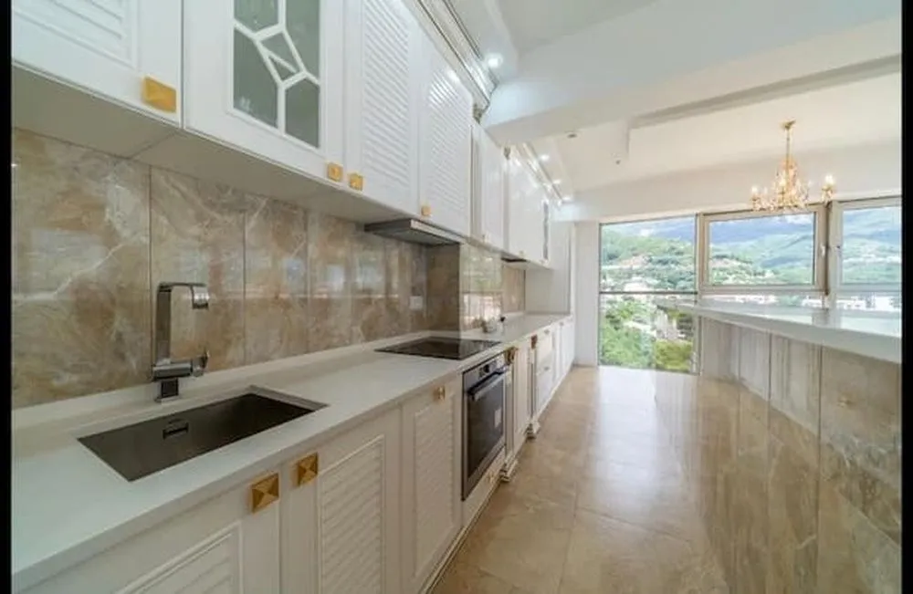 Modern kitchen with white cabinetry and a view of nature.