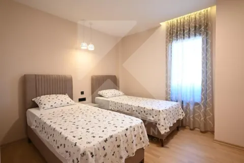Bedroom with two single beds and a window with curtains. - image 7