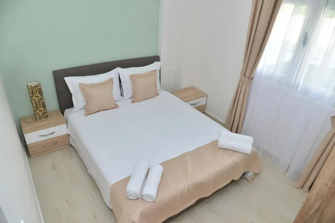 Furnished bedroom with a double bed, bedside tables and a window.