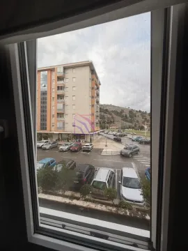 Pogled kroz prozor na parking i zgrade u naselju. - image 6