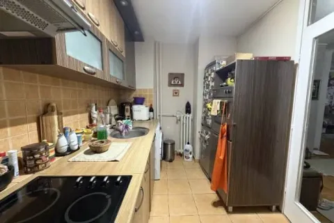 Dugačka kuhinja sa drvenim elementima, radnom površinom i ugradnim uređajima. - image 5